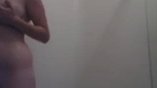 Jeune femme naturelle se touche sous la douche