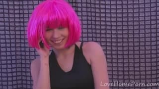 Une jeune femme aux cheveux roses se caresse