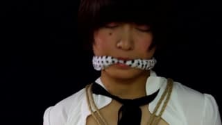 Trans ligotée et bâillonnée en scène de bondage