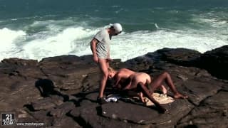 Une blonde dévergondée se fait baiser par deux hommes à la mer