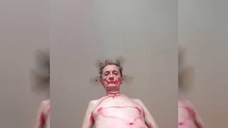 Un vieux gay qui se peint en rouge et qui danse