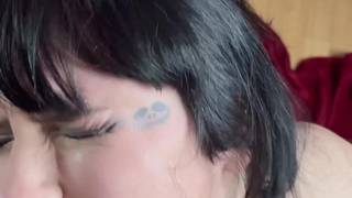 Une brune aux lèvres rouges suce la bite d'un amant