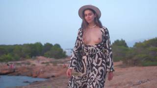 Alissa se promène sur la côte, les seins à l'air